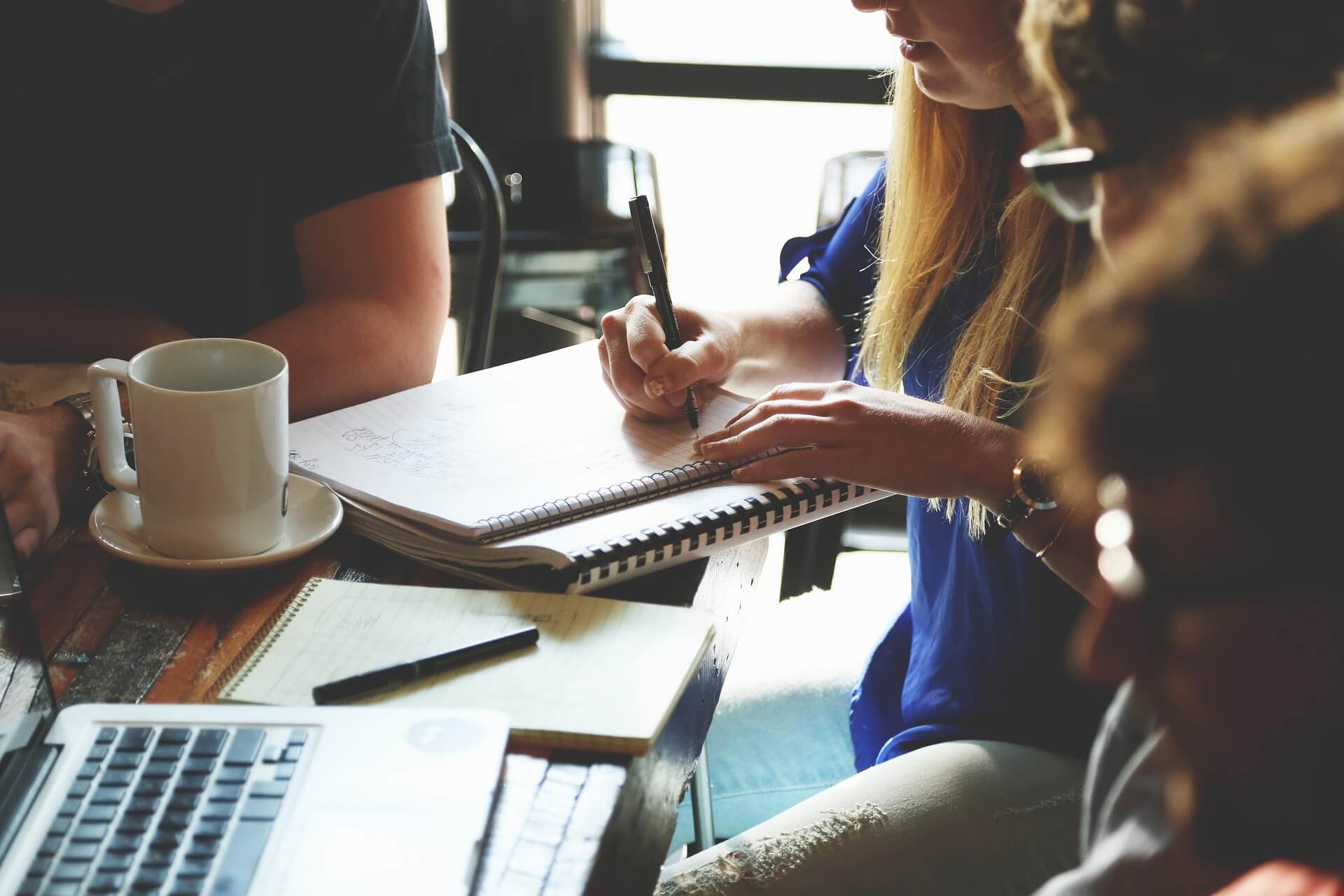 people having a meeting with laptop and notes